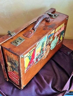 Antica valigia di cuoio con adesivi, interno foderato i