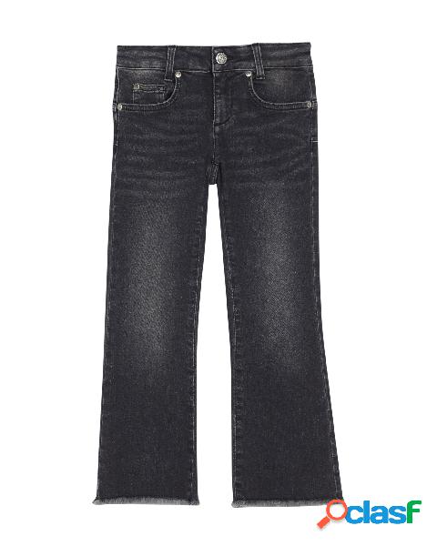 Jeans nero stone washed a trombetta con fondo sfrangiato